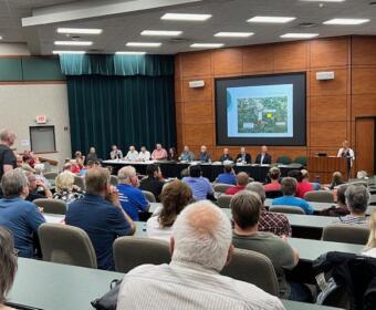 Mitchell South Dakota state prison proposal public forum prison project Mitchell South Dakota prison site land cost $35,000 per acre prison land economic impact of new prison 240 new prison jobs South Dakota Mitchell community prison concerns inmate parole and health care impact property value prison development South Dakota Department of Corrections