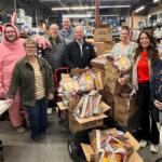 Volunteers prepare weekend snack packs for Mitchell students, part of a program distributing more than 90,000 food items annually.