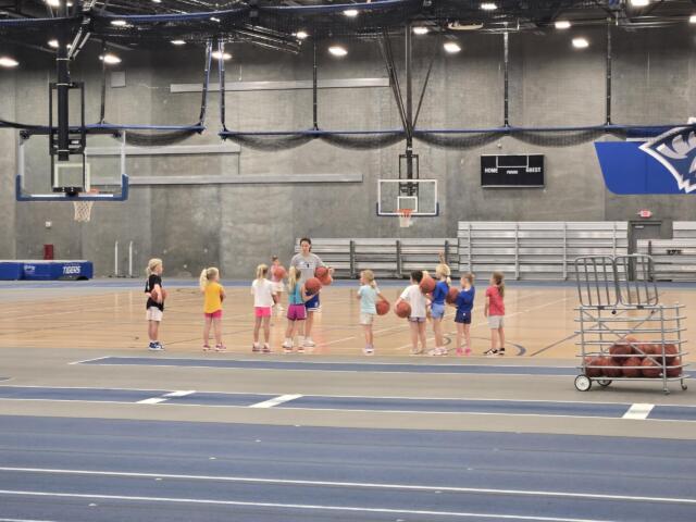 Kids and coaches in a gym for a basketball camp