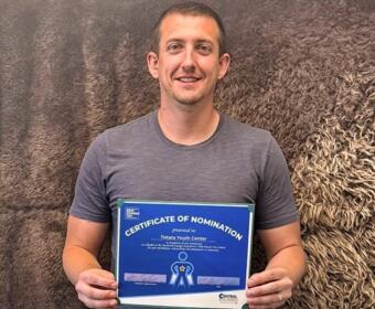 Tokata Youth Center's Aaron Vaughn with an award from the "Who Powers You" contest.