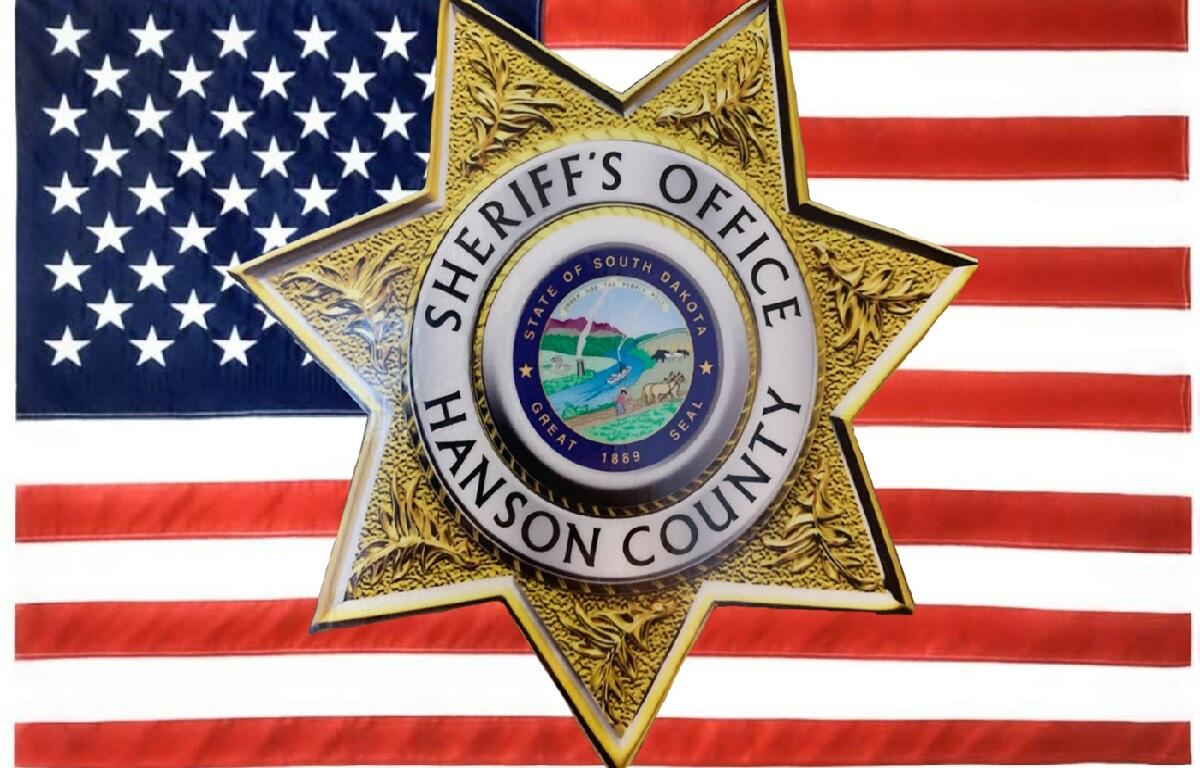 Hanson County Sheriff badge with American flag background.