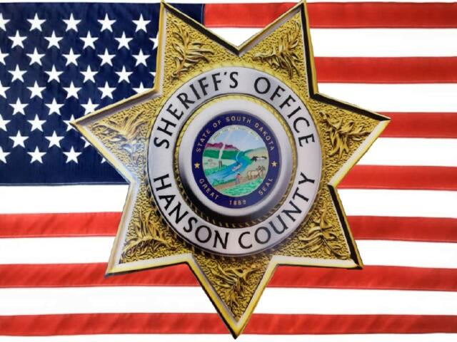 Hanson County Sheriff badge with American flag background.