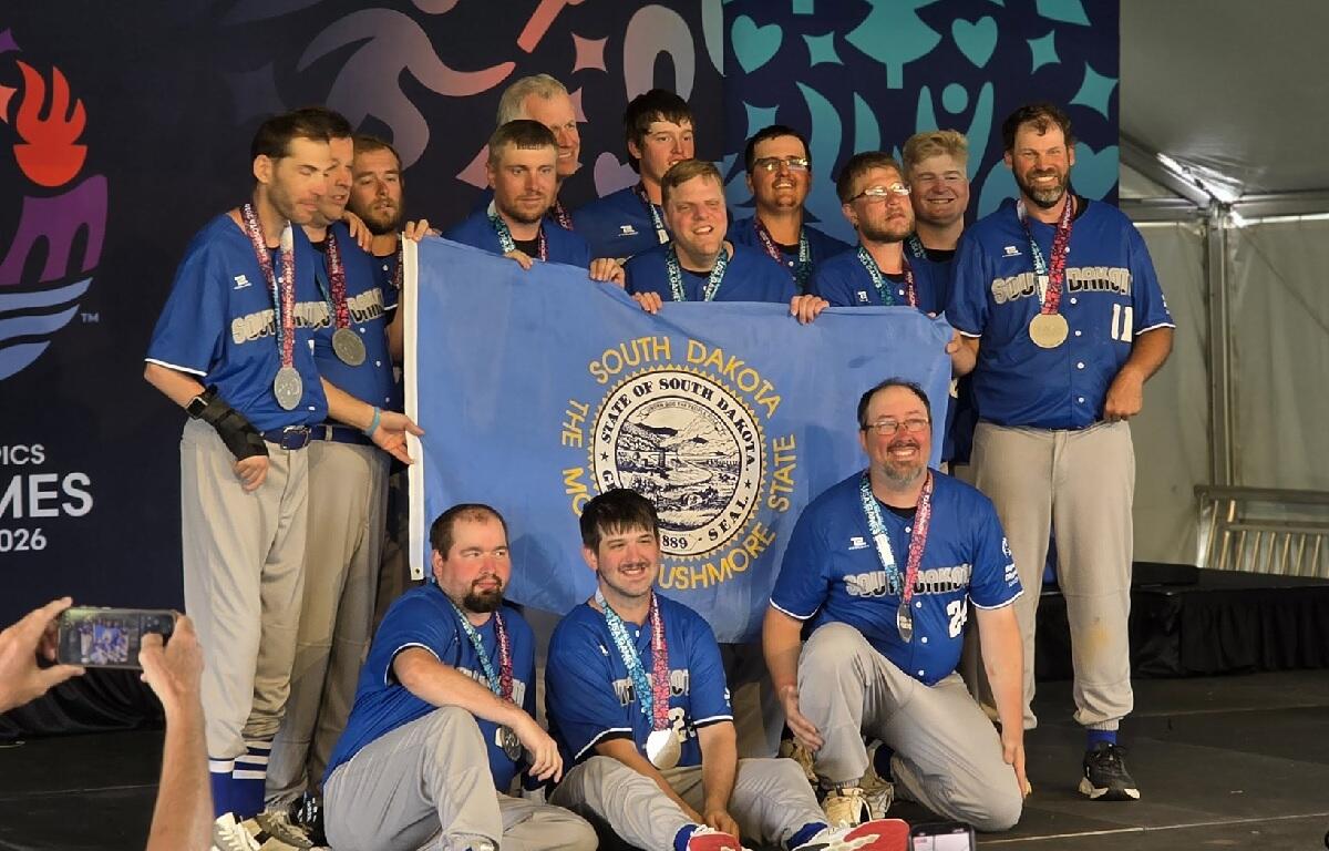 The South Dakota Special Olympics softball team poses with the state flag and their silver medals at the 2026 USA Games