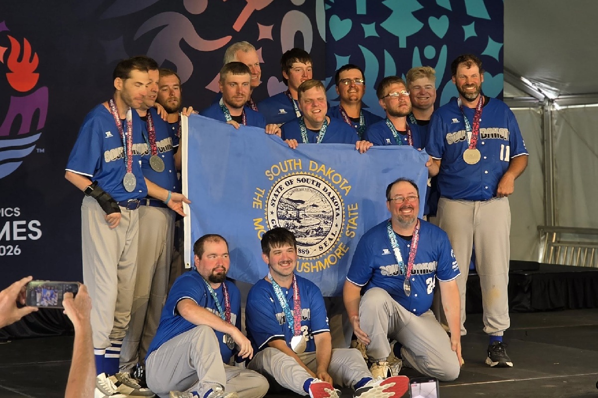 The South Dakota Special Olympics softball team poses with the state flag and their silver medals at the 2026 USA Games