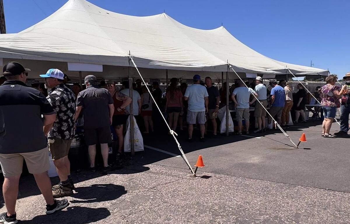 Throngs of people beat the heat under the tent at Saturday's Palace City Brewing Switchyard Social.