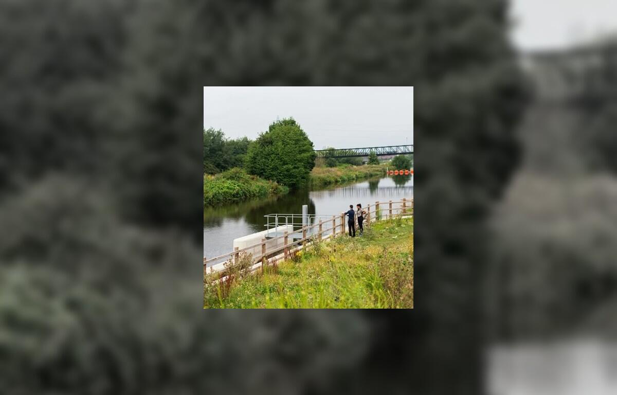 Two employees taking detailed notes about a lake shoreline