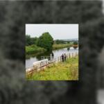 Two employees taking detailed notes about a lake shoreline