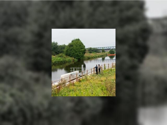 Two employees taking detailed notes about a lake shoreline