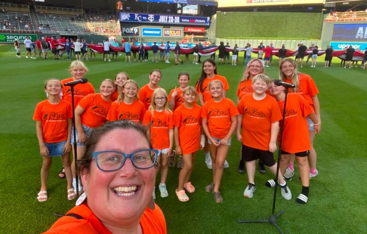 Mitchell Area Children's Choir and directors on the field ready to sing the anthem before a Twins game 7-10-26.