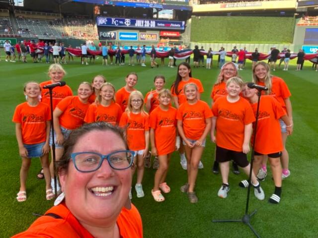 Mitchell Area Children's Choir and directors on the field ready to sing the anthem before a Twins game 7-10-26.